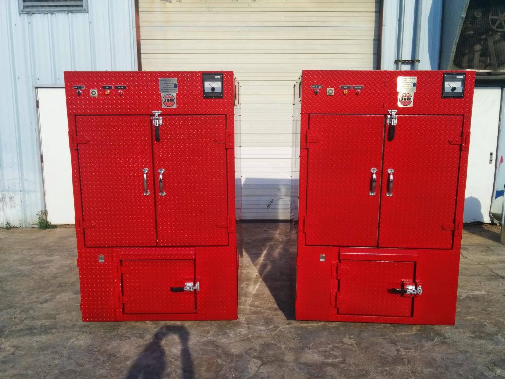 two red Oyler Pit smokers side by side